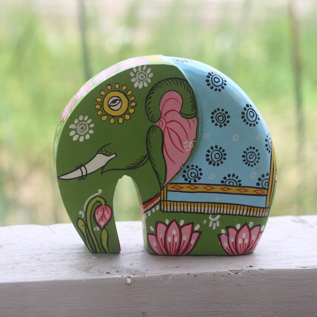 Colorful elephant-shaped object with floral patterns on a wooden surface