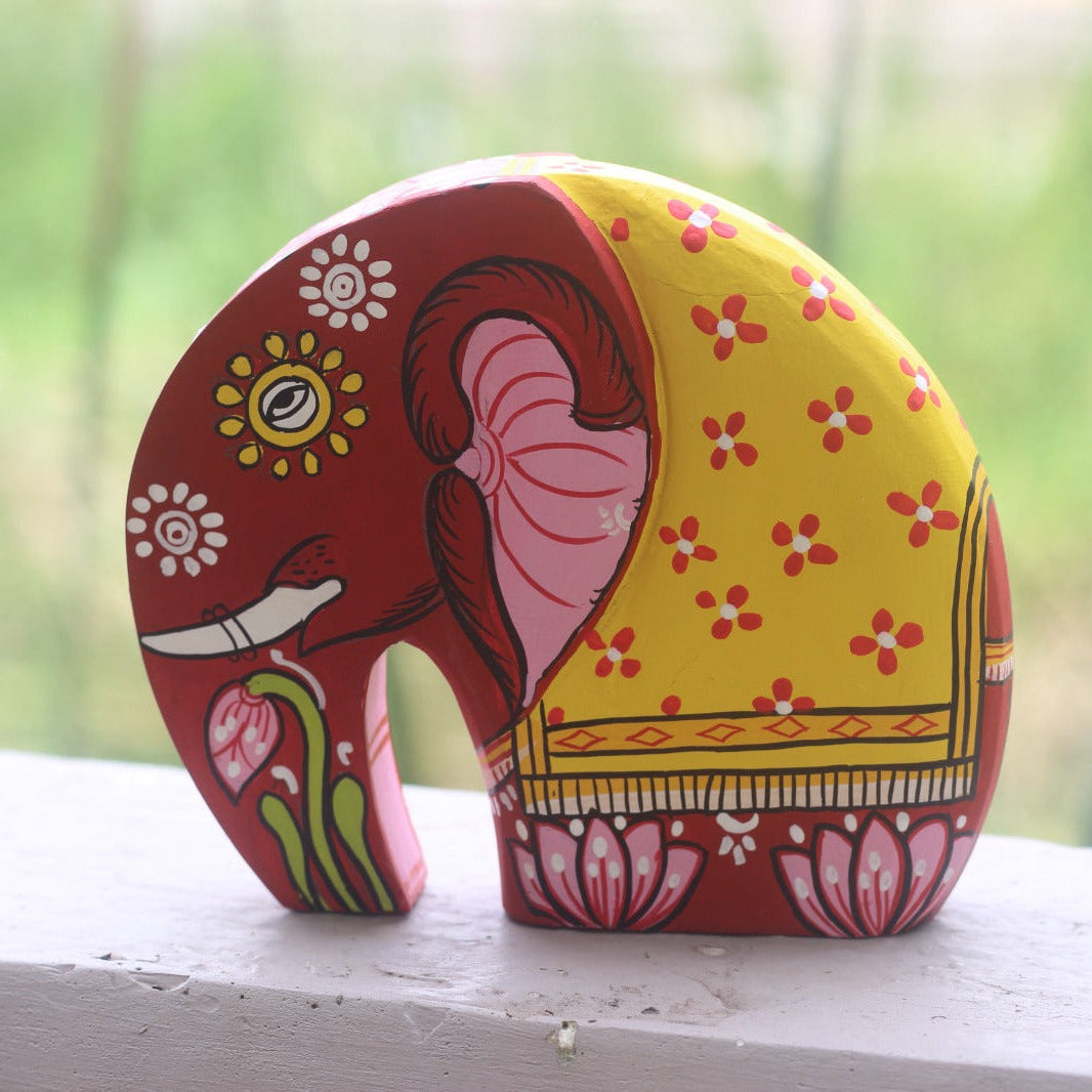 Decorative elephant figurine with colorful patterns on a white surface.
