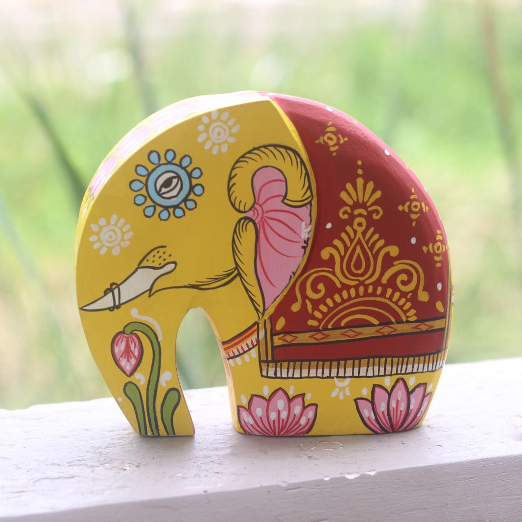 Decorative elephant figurine with colorful patterns on a wooden surface